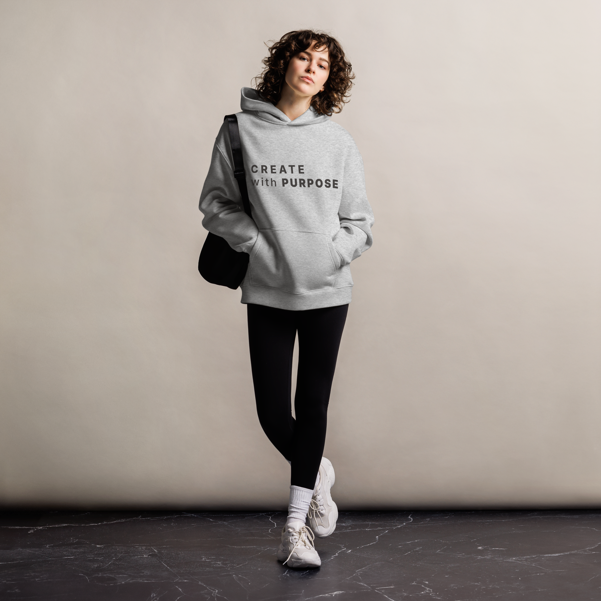Athletic Heather oversized hoodie worn by woman, relaxed streetwear fit with “CREATE with PURPOSE” print
