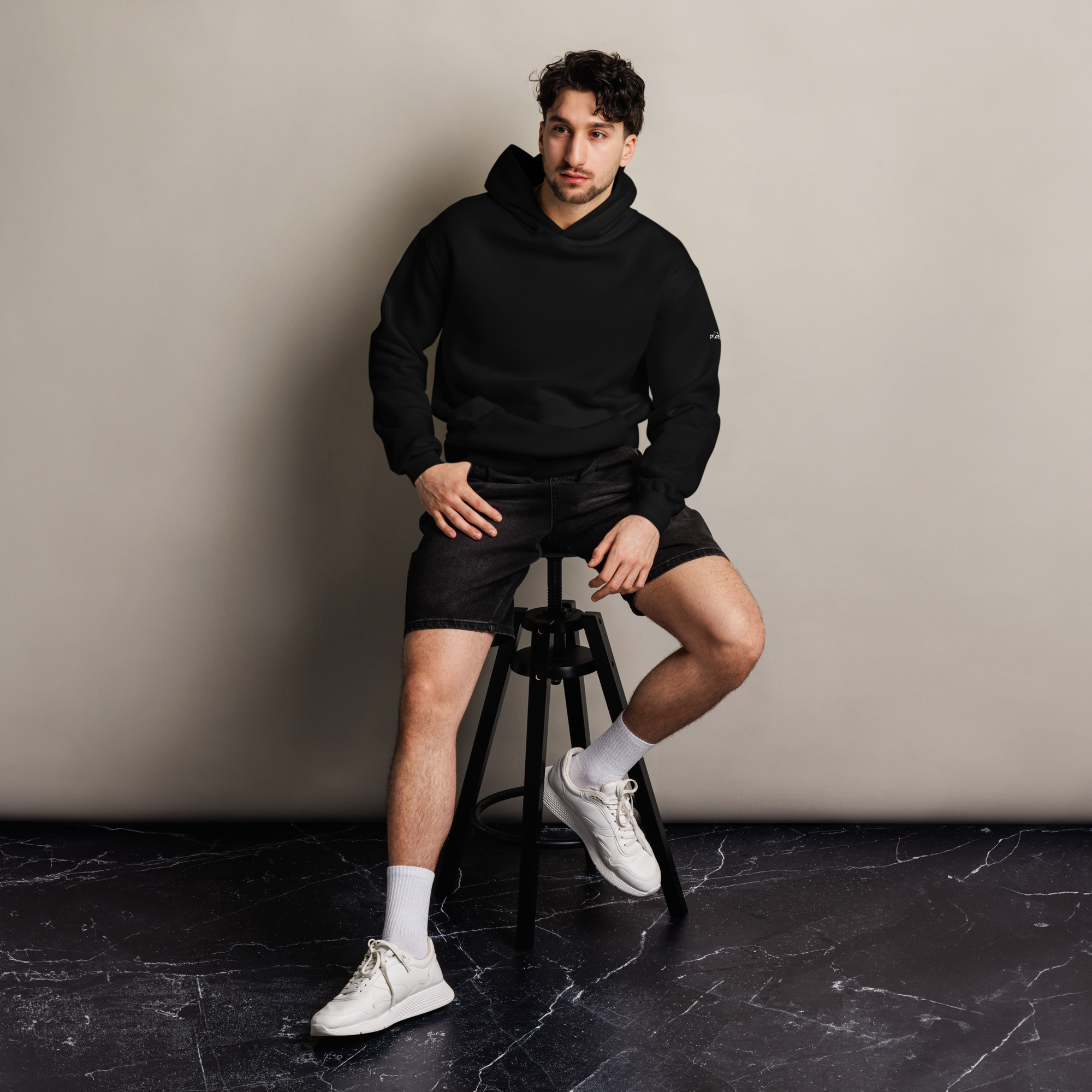 Black oversized hoodie editorial lifestyle worn by model sitting – The Pixel Wolf