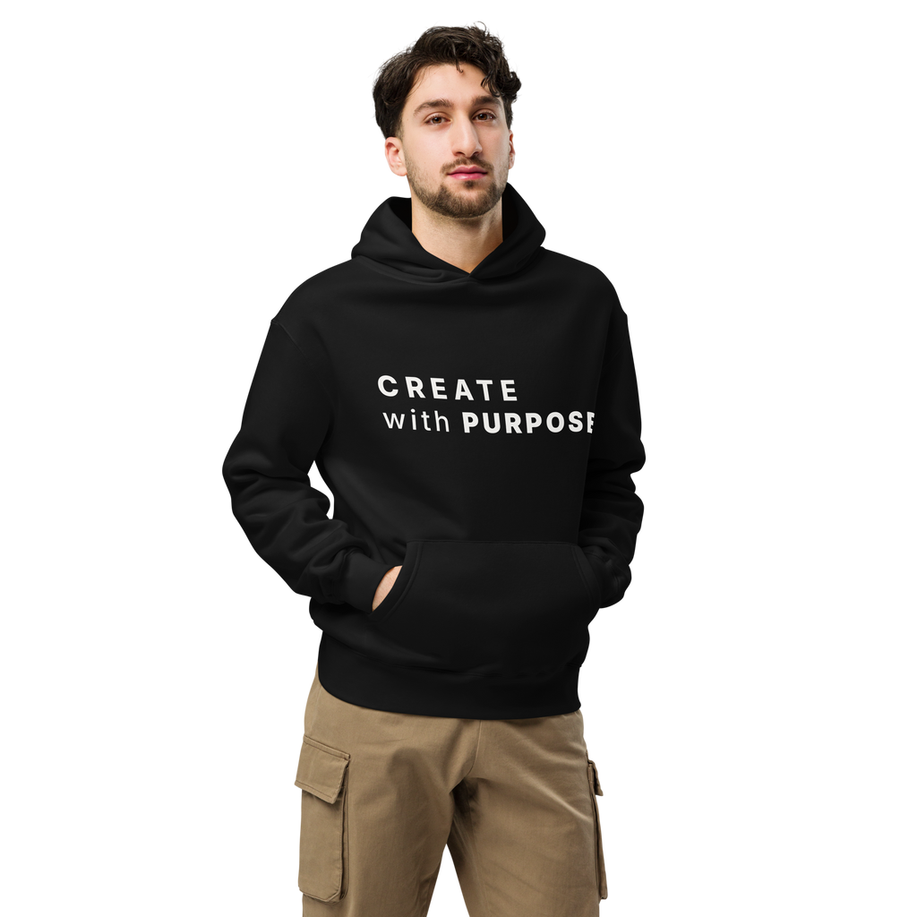 Black oversized hoodie worn by man, oversized silhouette with “CREATE with PURPOSE” print