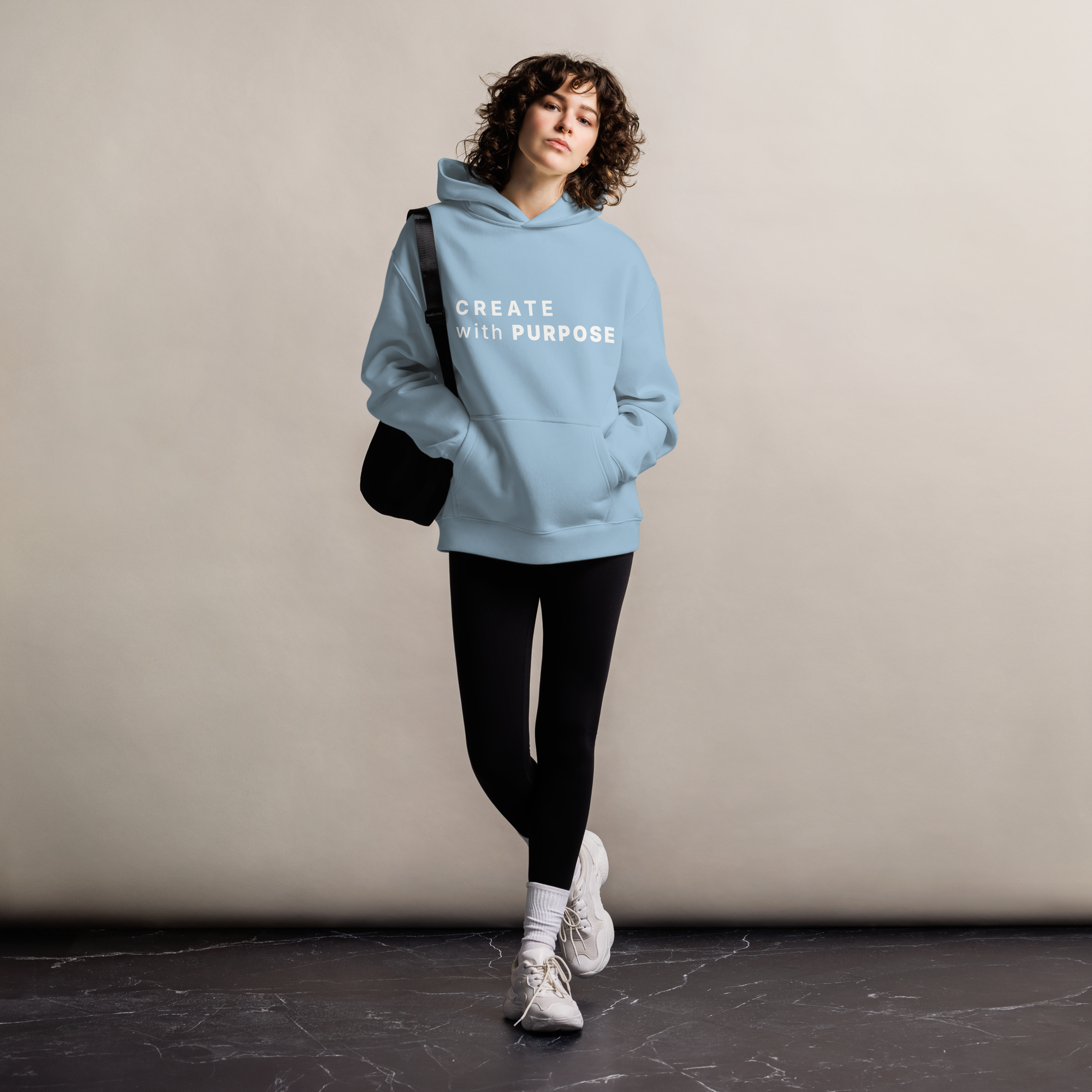 Carolina Blue oversized hoodie worn by woman, relaxed streetwear fit with “CREATE with PURPOSE” print