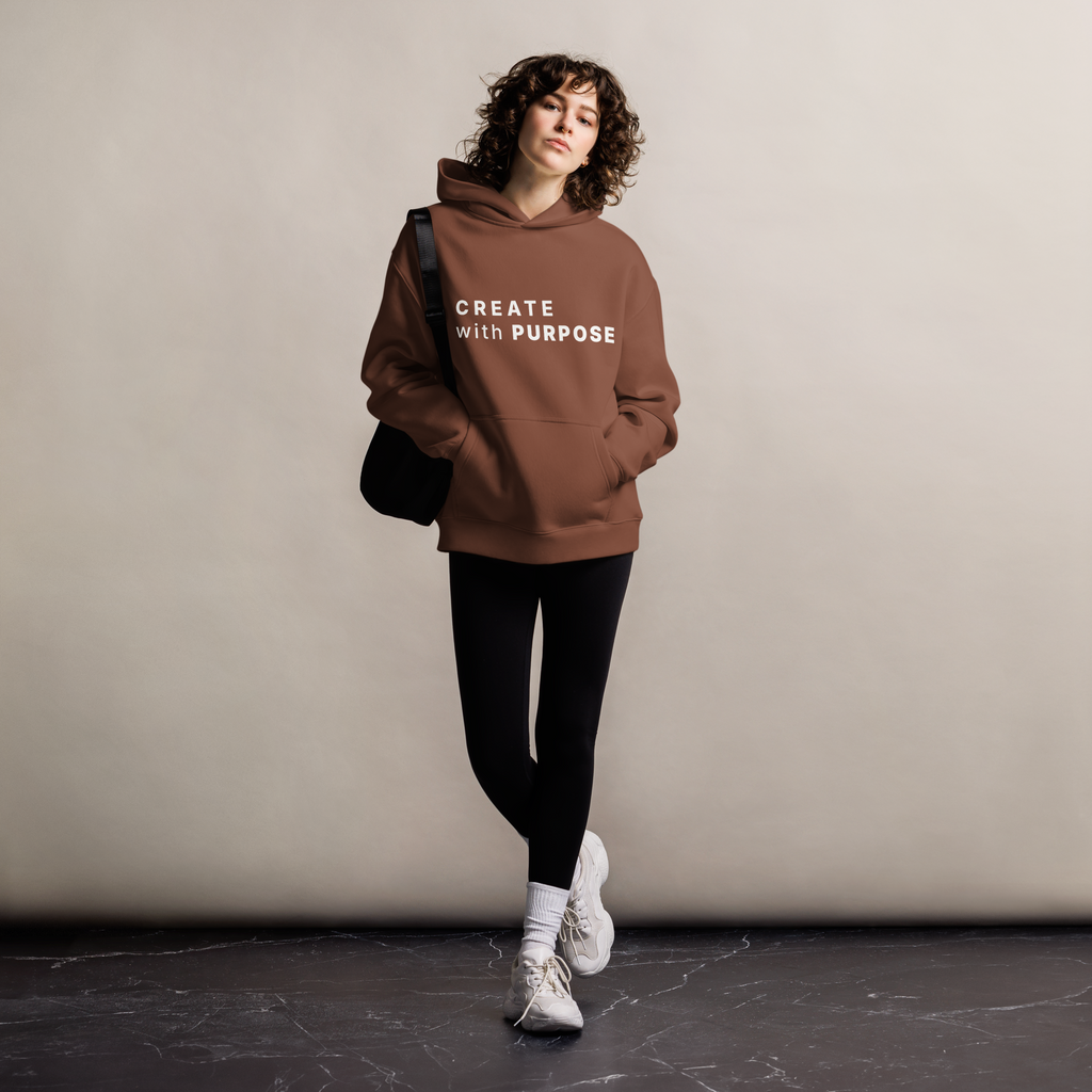 Chestnut oversized hoodie worn by woman, relaxed streetwear fit with “CREATE with PURPOSE” print