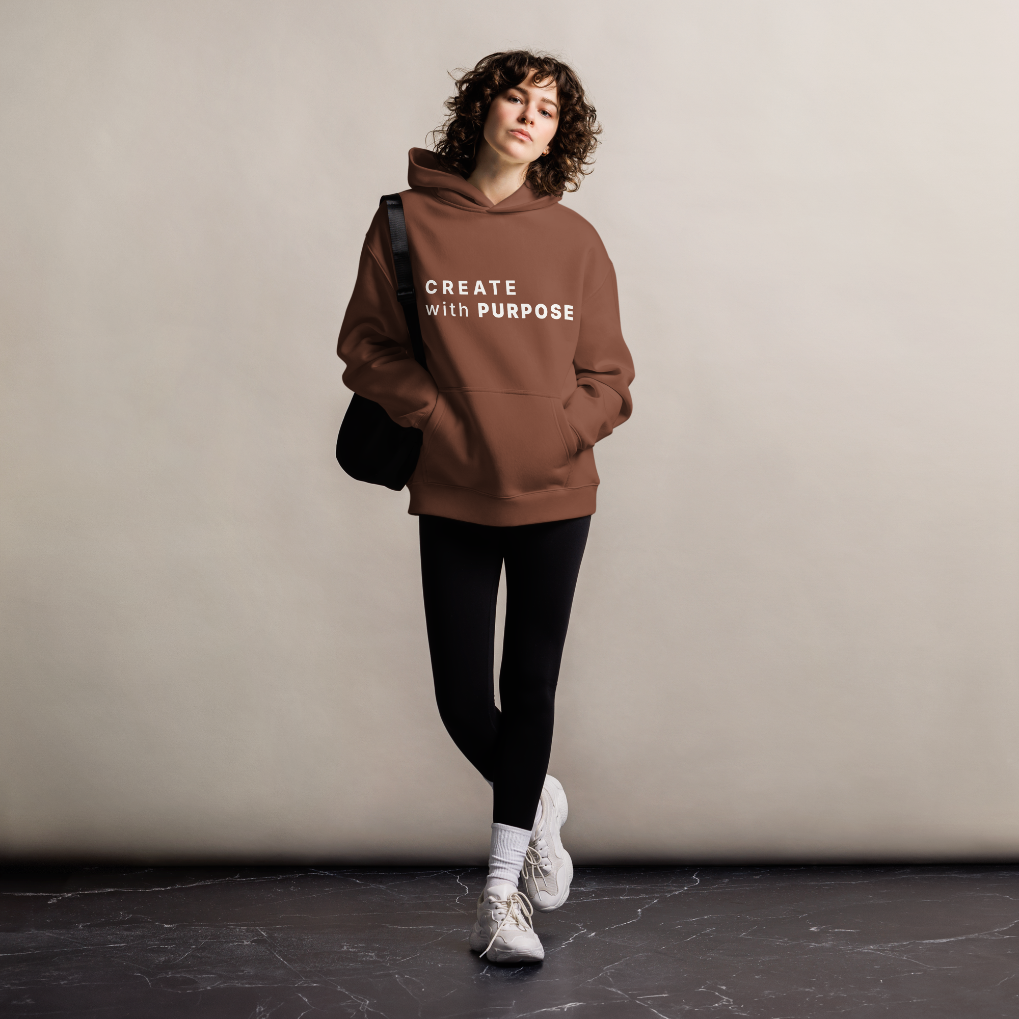 Chestnut oversized hoodie worn by woman, relaxed streetwear fit with “CREATE with PURPOSE” print