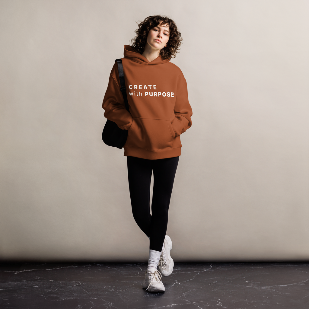 Clay oversized hoodie worn by woman, relaxed streetwear fit with “CREATE with PURPOSE” print