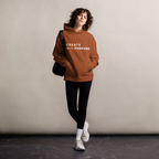Clay oversized hoodie worn by woman, relaxed streetwear fit with “CREATE with PURPOSE” print