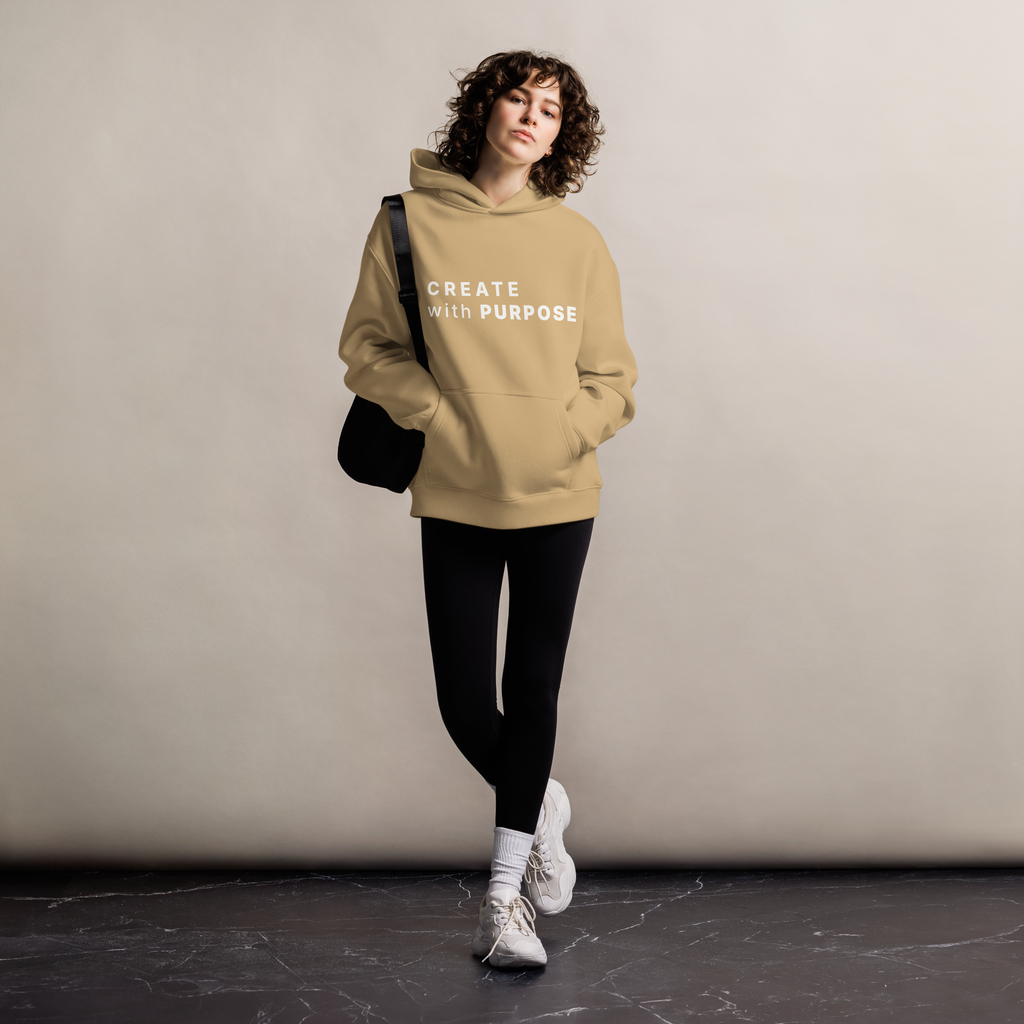 Sand oversized hoodie worn by woman, relaxed streetwear fit with “CREATE with PURPOSE” print