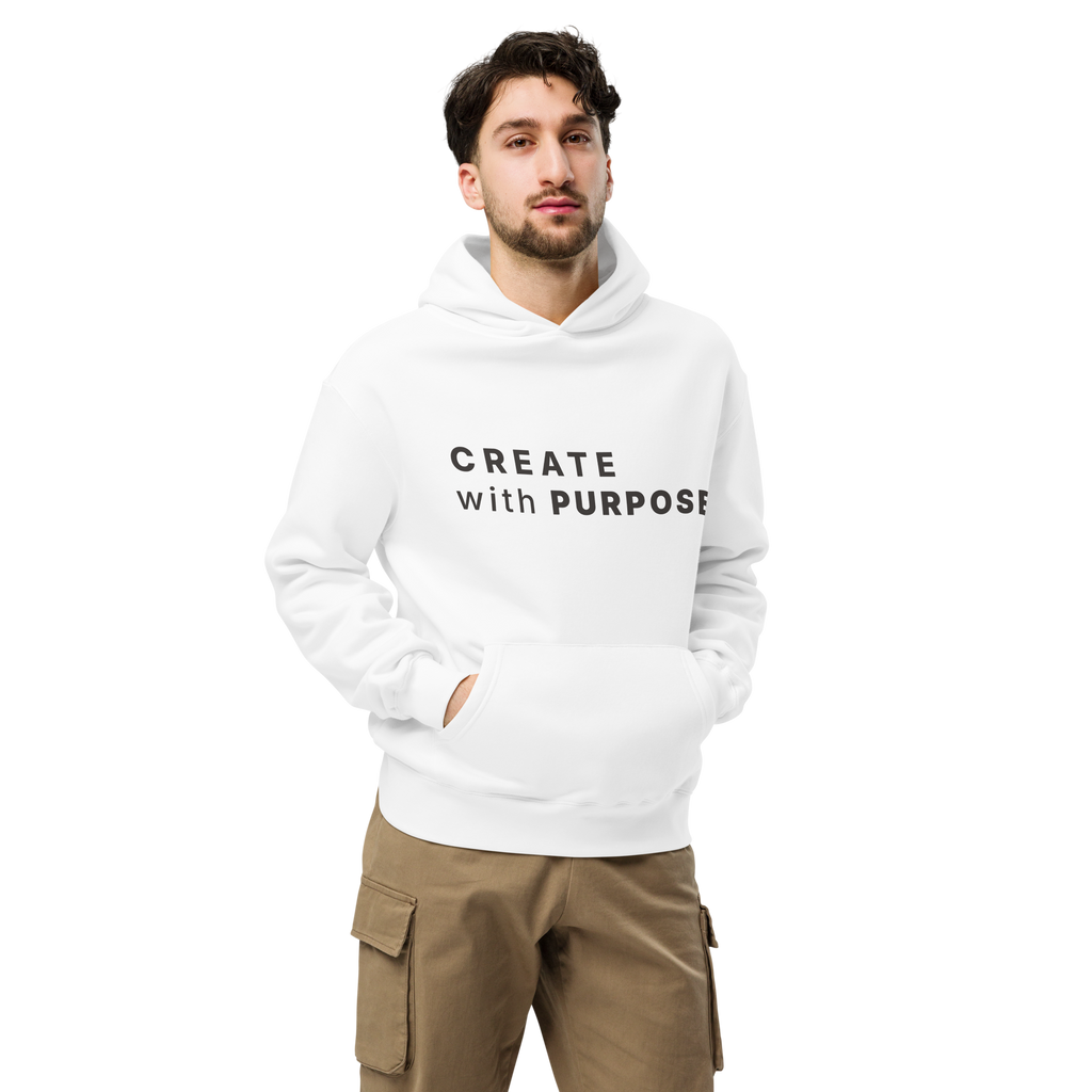 White oversized hoodie worn by man, oversized silhouette with “CREATE with PURPOSE” print
