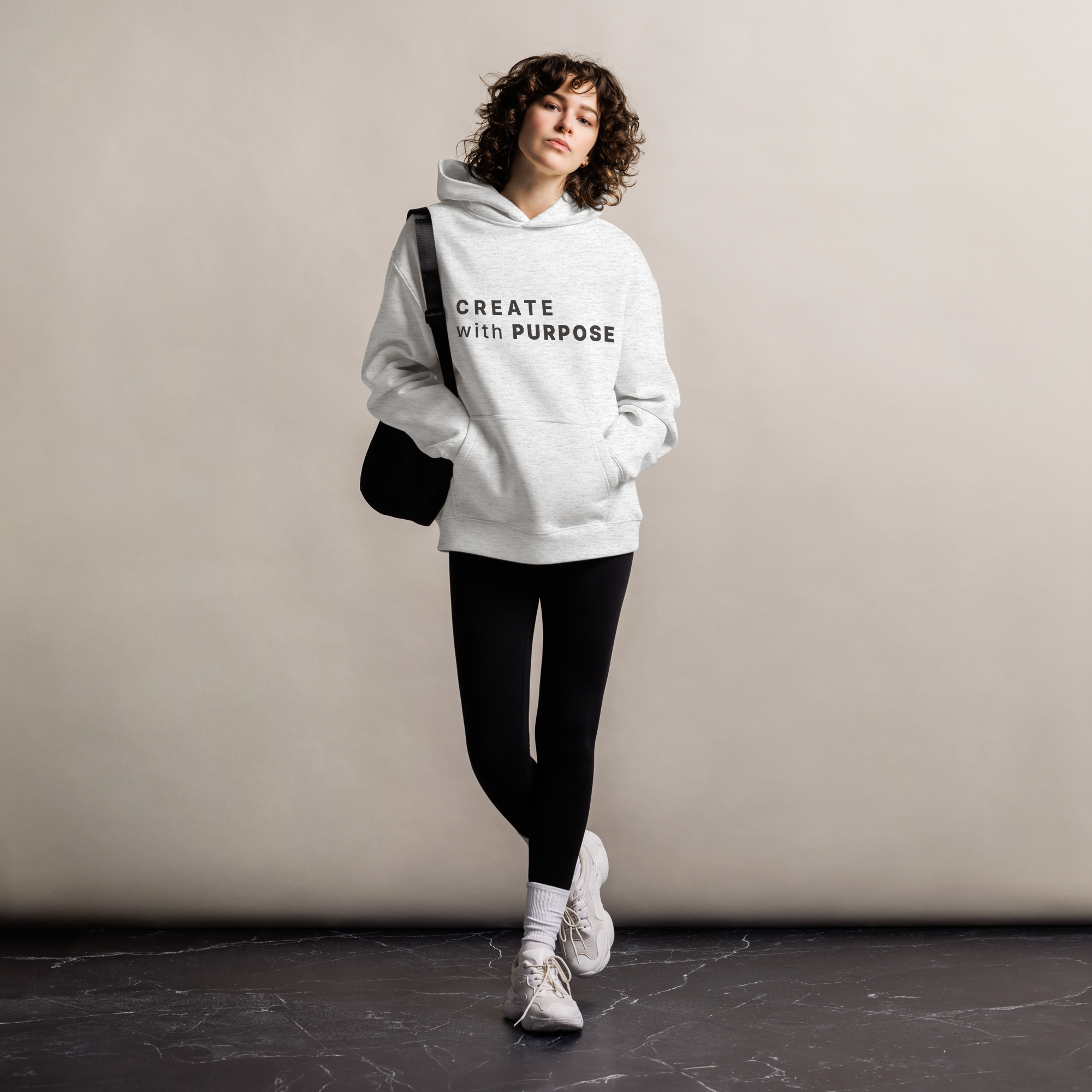 White Heather oversized hoodie worn by woman, relaxed streetwear fit with “CREATE with PURPOSE” print