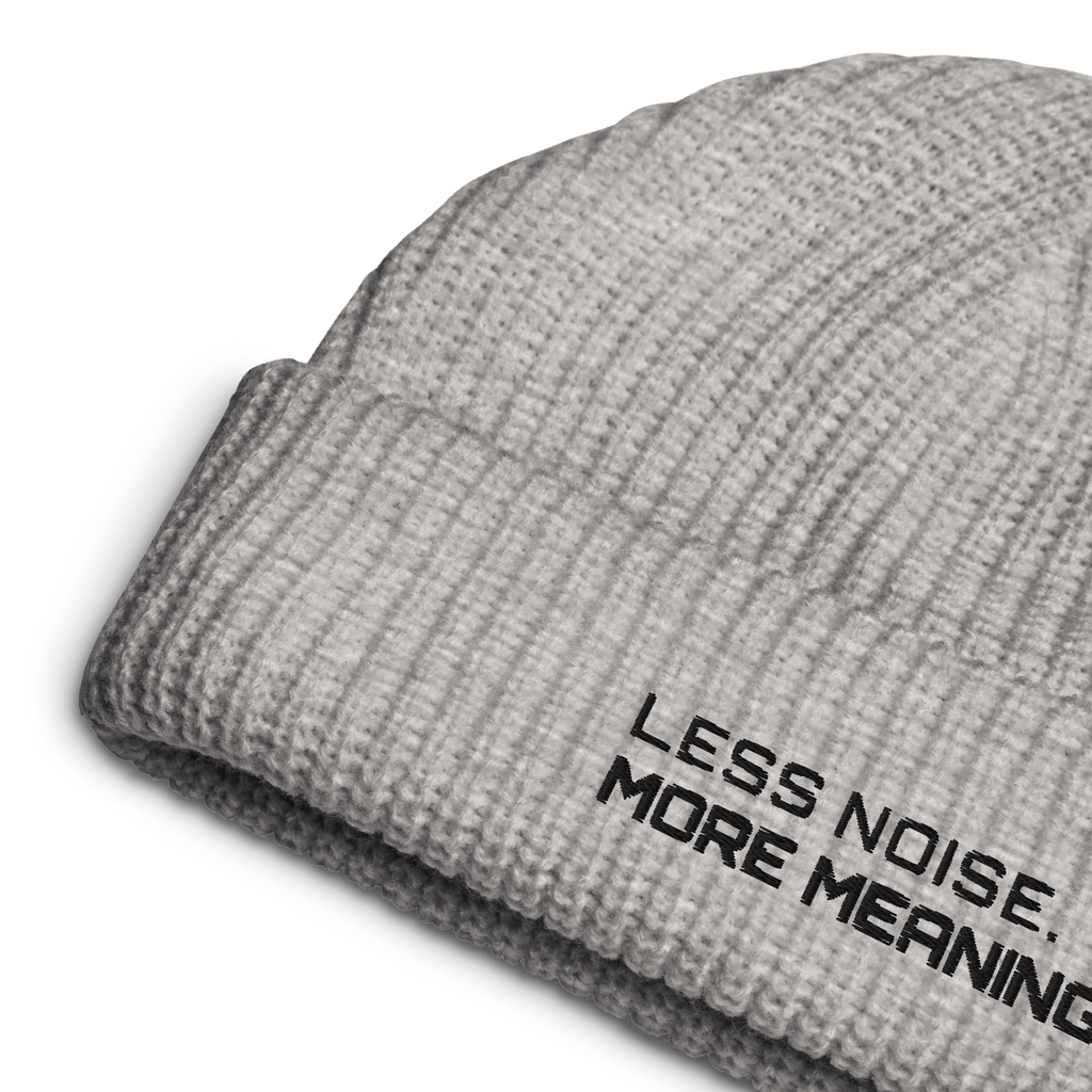 Athletic Heather fisherman beanie close-up showing embroidered Less Noise More Meaning slogan