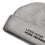 Athletic Heather fisherman beanie close-up showing embroidered Less Noise More Meaning slogan