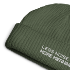 Cypress fisherman beanie close-up showing embroidered Less Noise More Meaning slogan