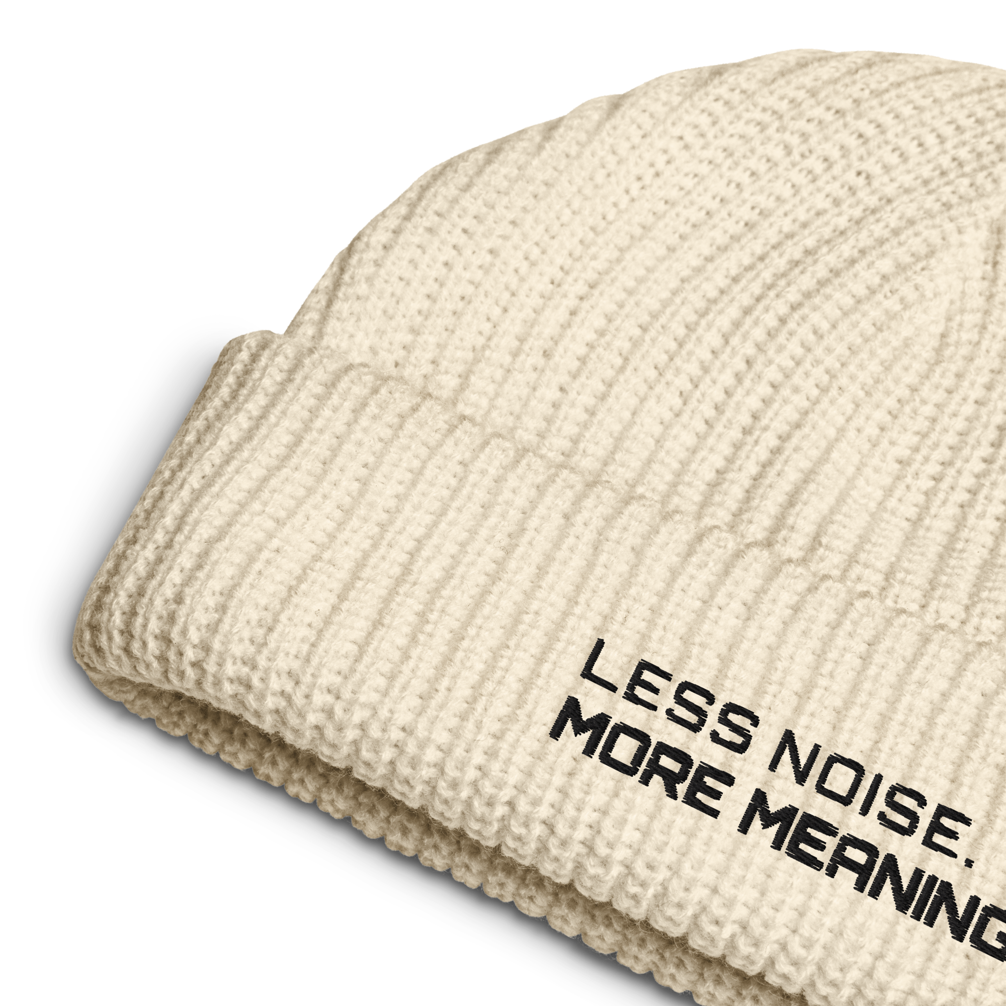 Ecru fisherman beanie close-up showing embroidered Less Noise More Meaning slogan
