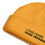 Gold fisherman beanie close-up showing embroidered Less Noise More Meaning slogan
Gold fisherman beanie worn in lifestyle setting with minimalist outfit