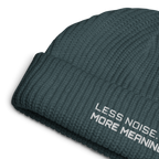 Petrol Blue fisherman beanie close-up showing embroidered Less Noise More Meaning slogan