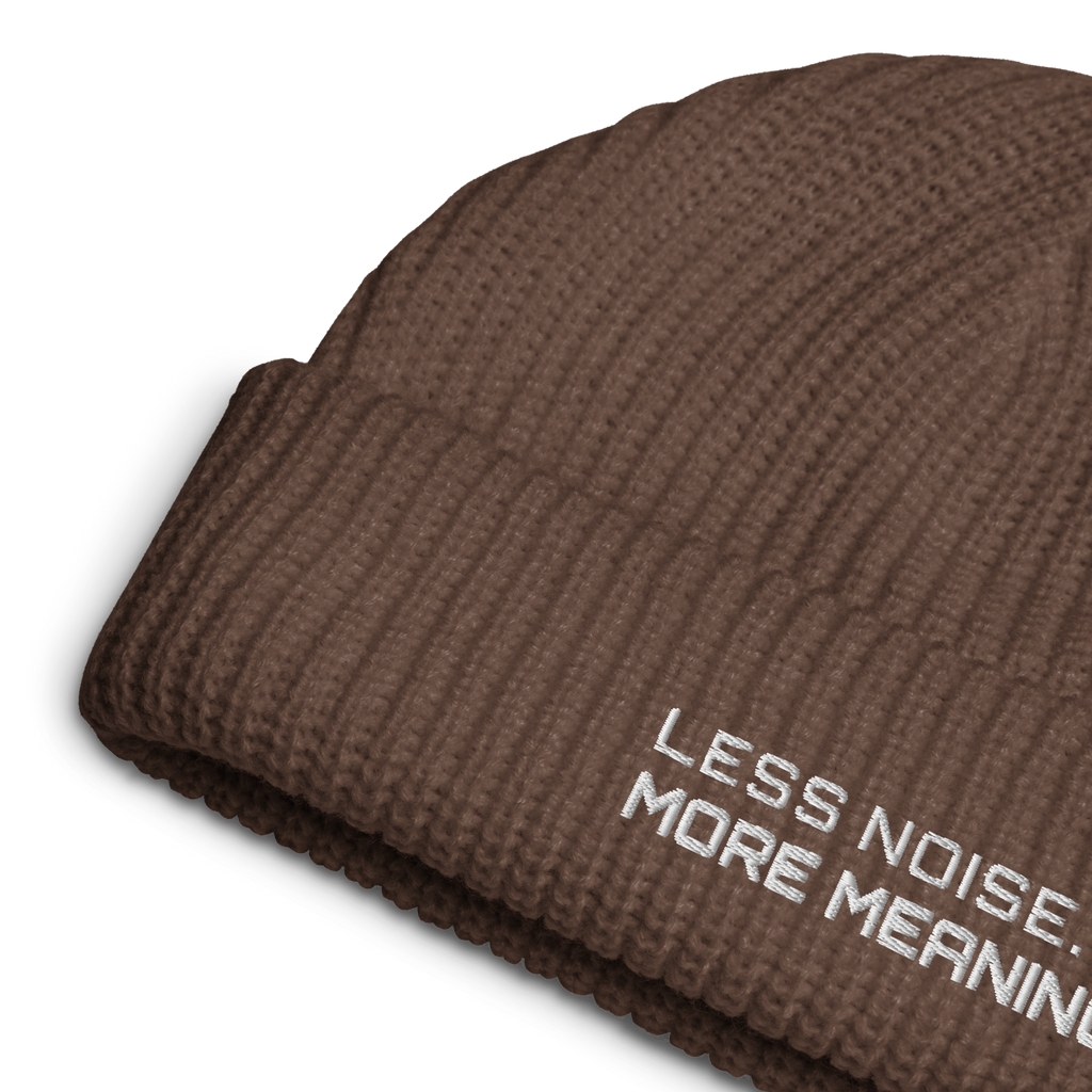 Walnut fisherman beanie close-up showing embroidered Less Noise More Meaning slogan